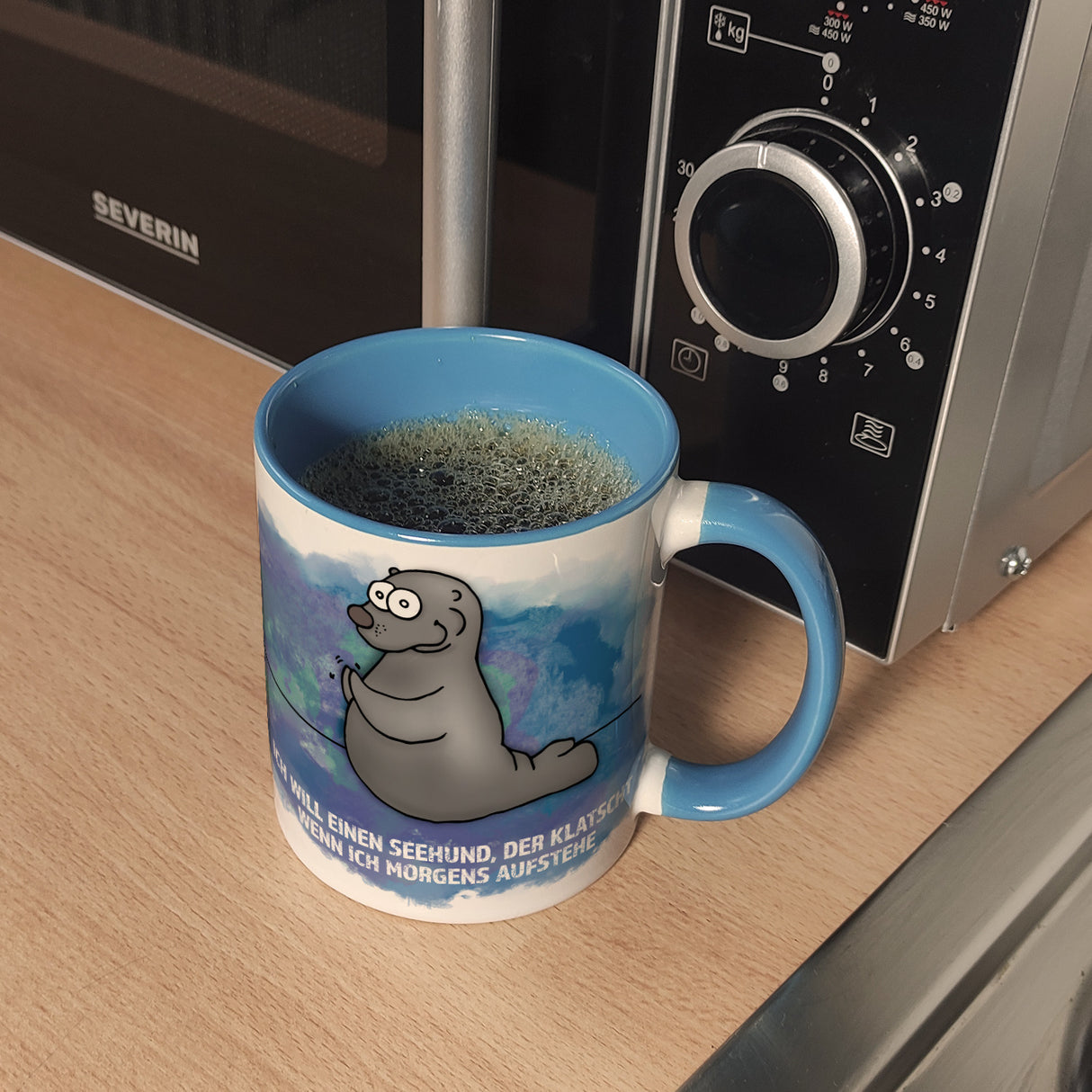 Kaffeebecher mit Seehund Motiv und Spruch: Ich will einen Seehund, der klatscht, ...