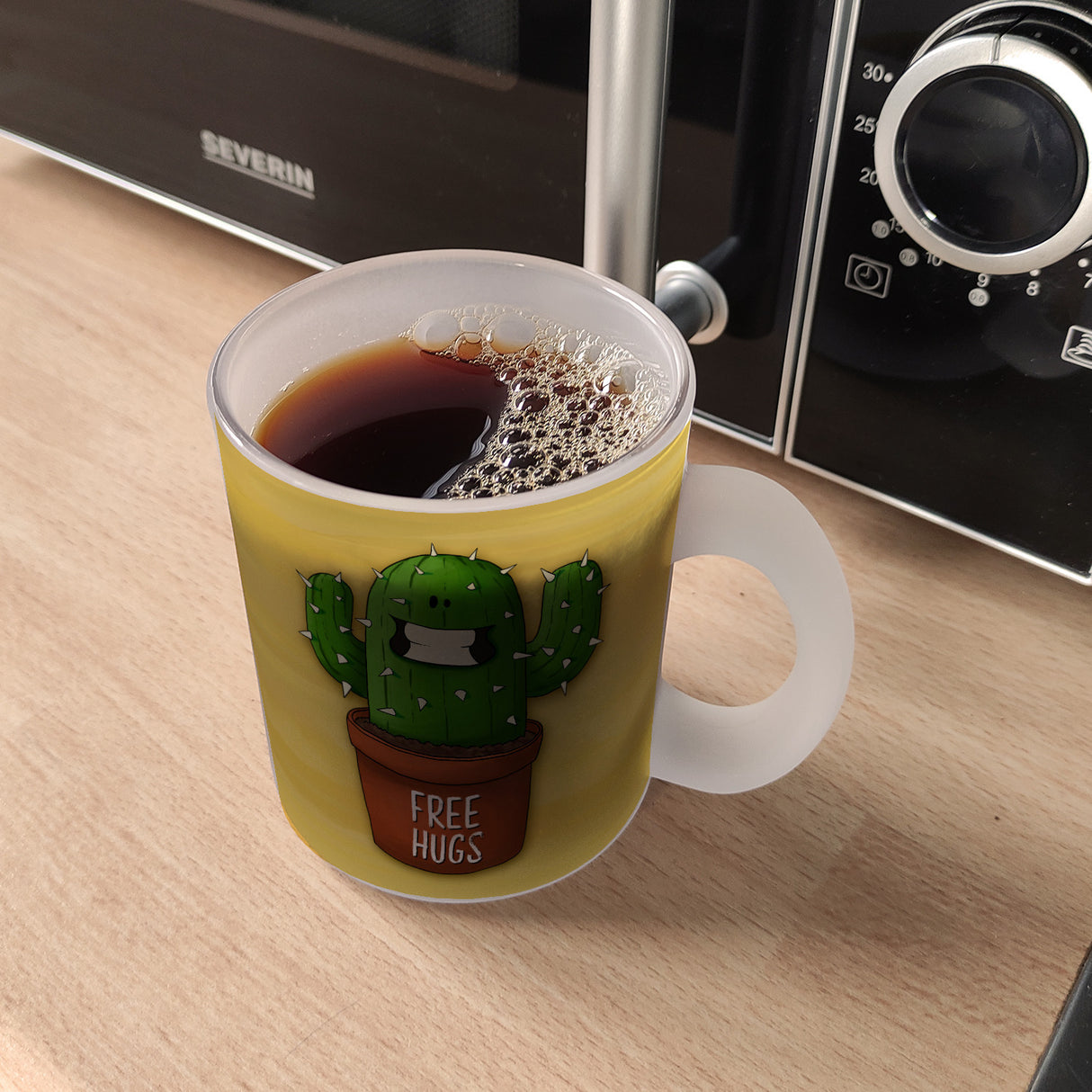 Kaffeebecher mit freundlicher Kaktus Motiv und Spruch: Free Hugs