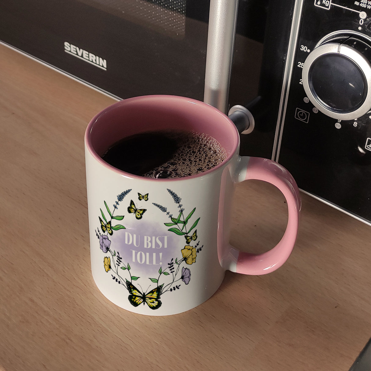 Kaffeebecher mit motivierenden Worten und Blumenrahmen mit Schmetterlingen