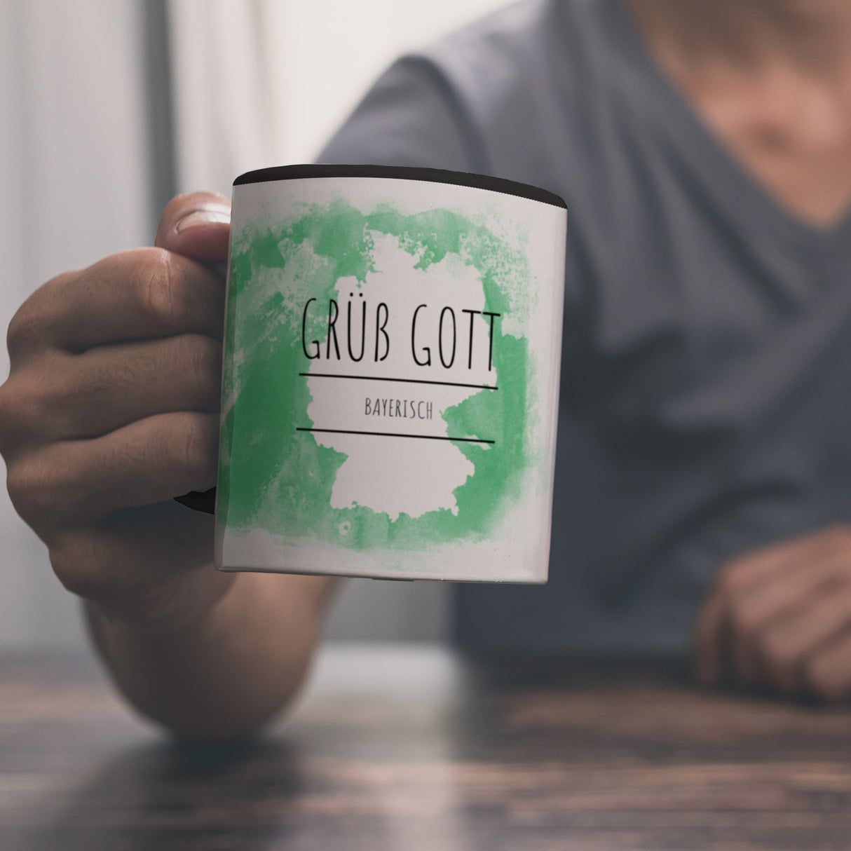 Hallo auf Bayerisch Grüß Gott lustiger Kaffeebecher mit grünem Hintergrund