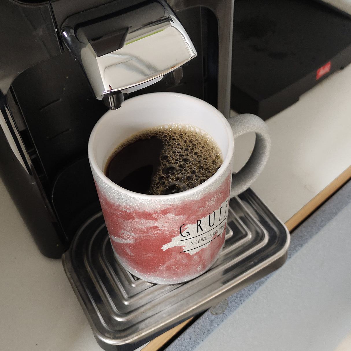 Hallo auf Schweizerdeutsch Grüezi lustiger Kaffeebecher mit rotem Hintergrund