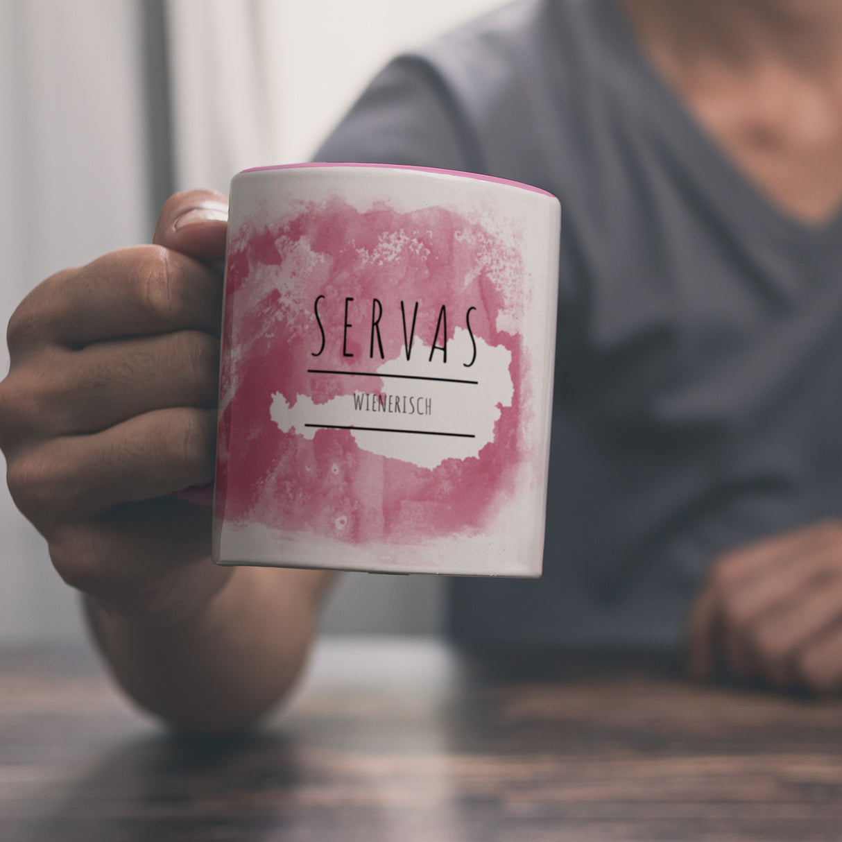 Hallo auf Wienerisch Servas lustiger Kaffeebecher mit rosaem Hintergrund