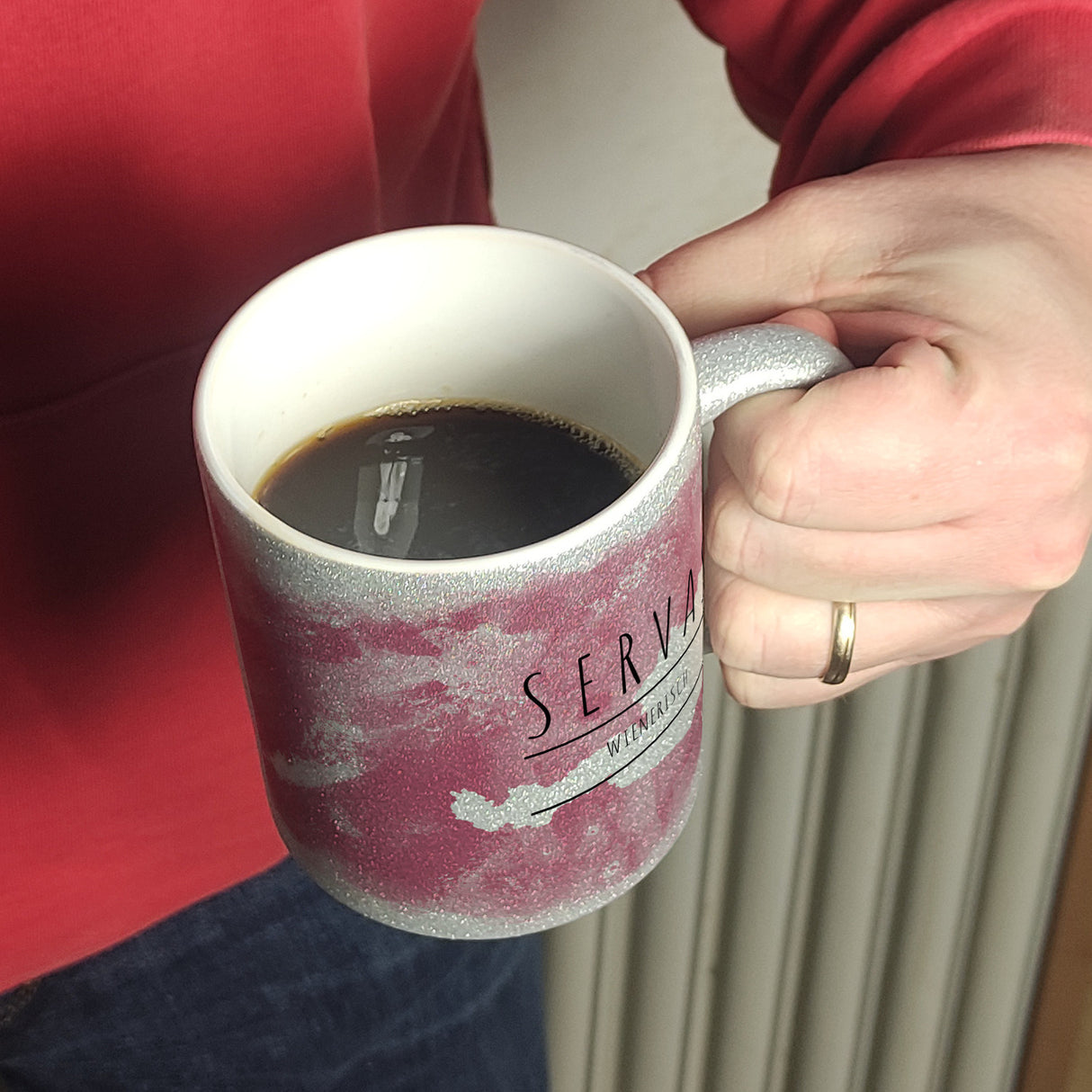 Hallo auf Wienerisch Servas lustiger Kaffeebecher mit rosaem Hintergrund