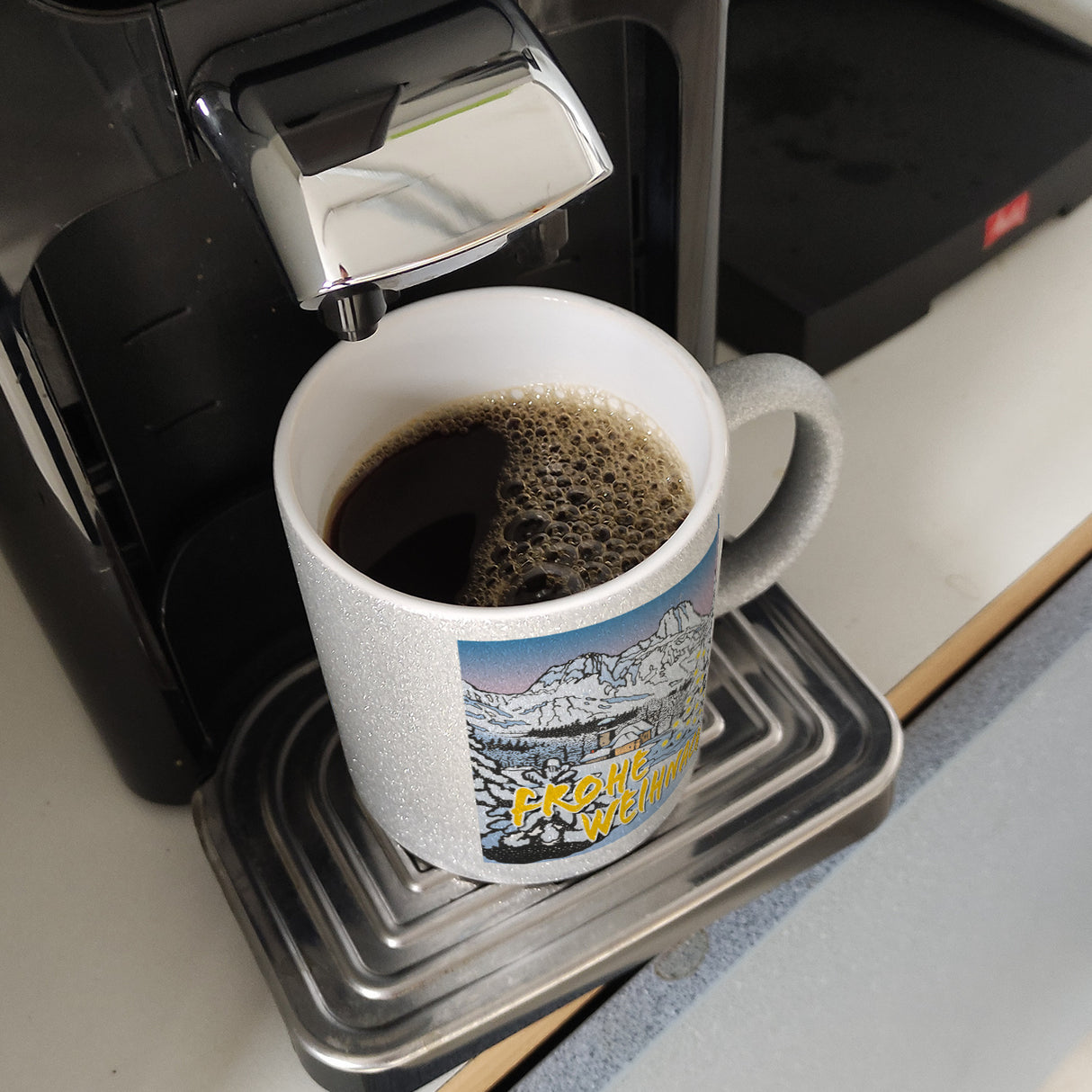 Kaffeebecher zum Thema Weihnachten mit eingeschneiter Landschaft