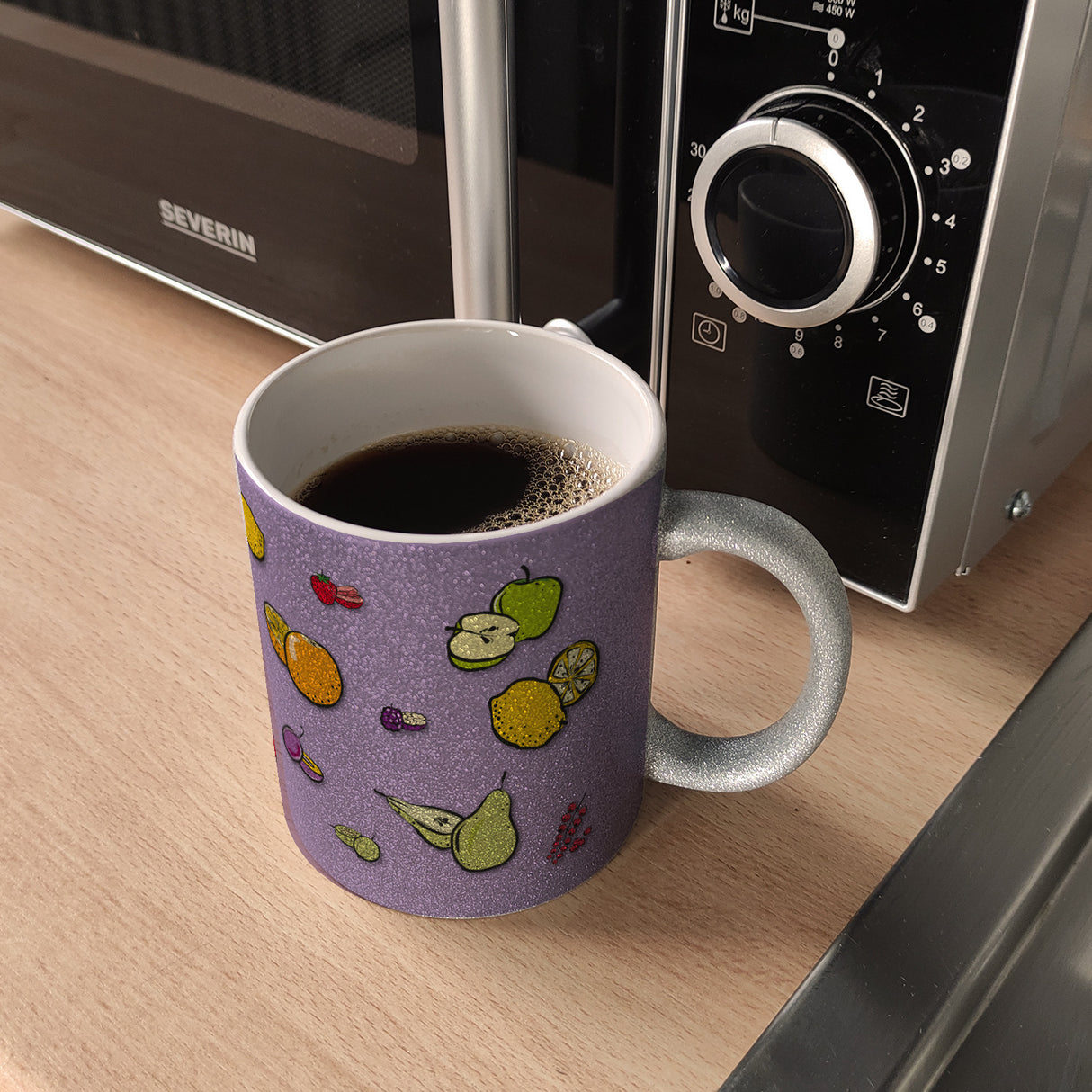 Kaffeebecher in lila zum Thema Obst mit verschiedenen Früchten