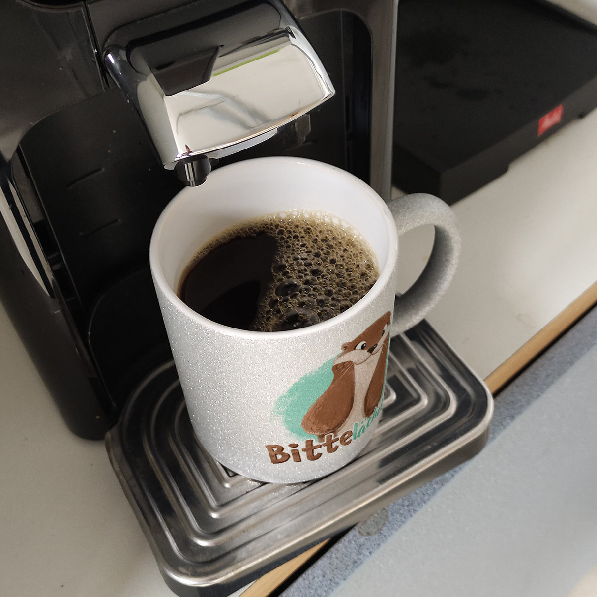 Lachender Otter Kaffeebecher mit Spruch Bitte lächeln