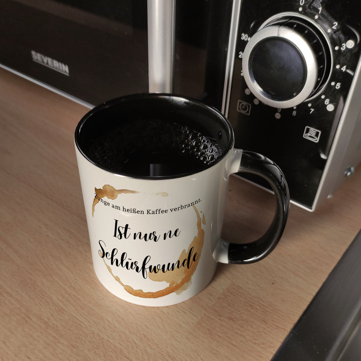 Kaffeefleck Kaffeebecher mit Spruch Zunge am heißen Kaffee verbrannt