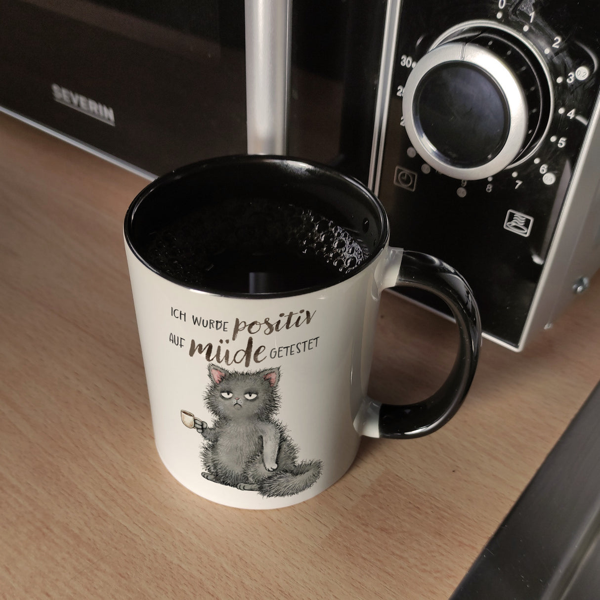 Katze mit Tasse Kaffeebecher mit Spruch positiv auf müde getestet
