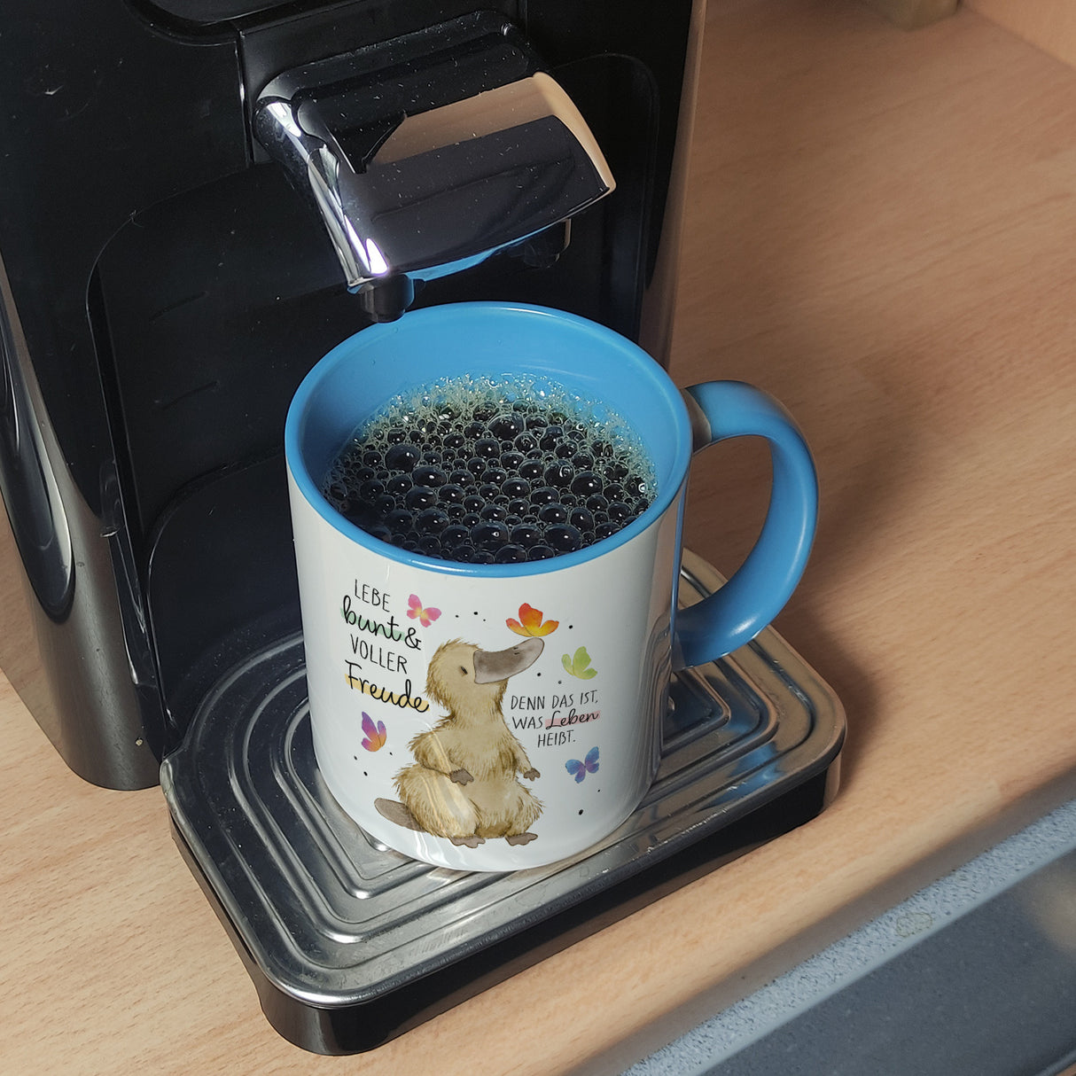 Schnabeltier Kaffeebecher mit Spruch Lebe bunt und freudig