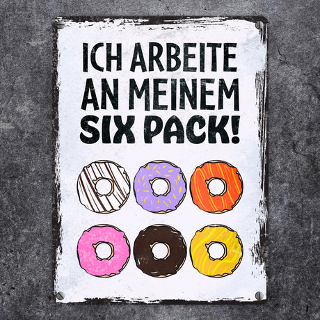 Ich arbeite an meinem Six Pack Metallschild mit leckeren Donuts