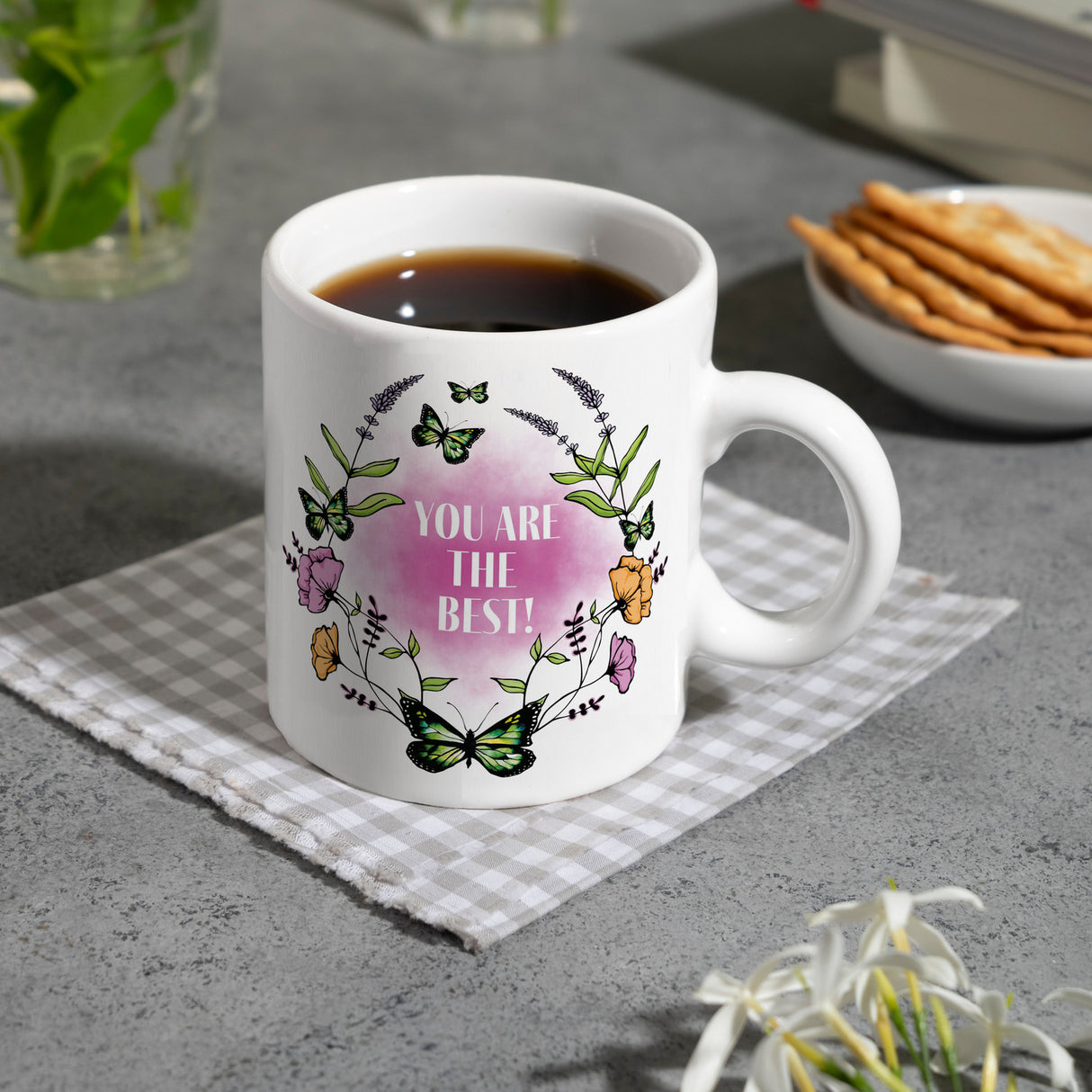 Kaffeebecher mit motivierenden Worten und Blumenrahmen mit Schmetterlingen