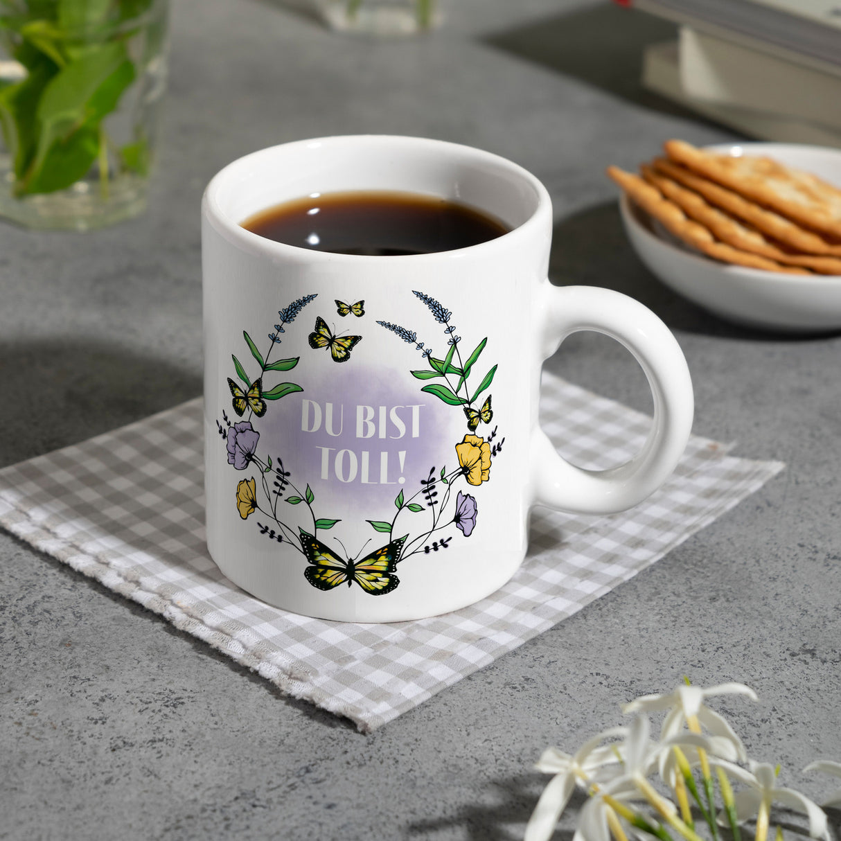 Kaffeebecher mit motivierenden Worten und Blumenrahmen mit Schmetterlingen