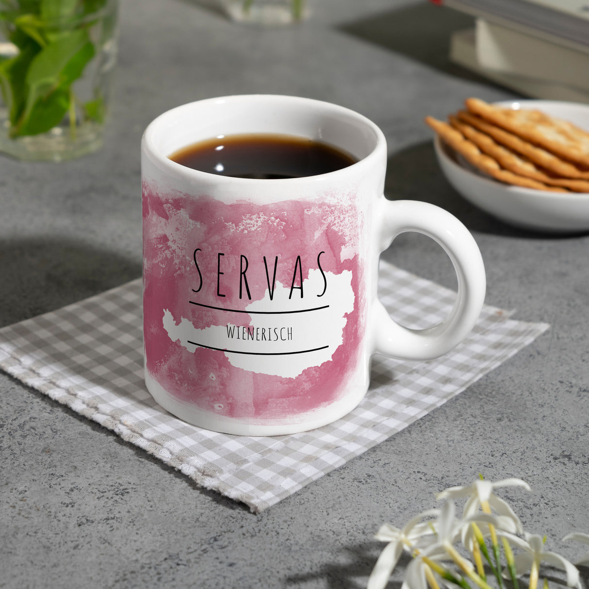 Hallo auf Wienerisch Servas lustiger Kaffeebecher mit rosaem Hintergrund