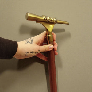 Hand mit Fernrohr Spazierstock aus Holz mit goldenem Griff aus Metall