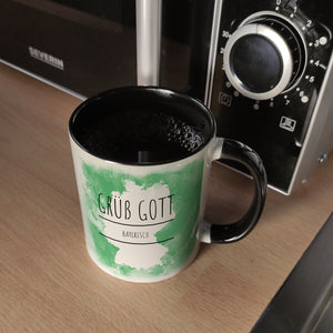 Hallo auf Bayerisch Grüß Gott lustiger Kaffeebecher mit grünem Hintergrund